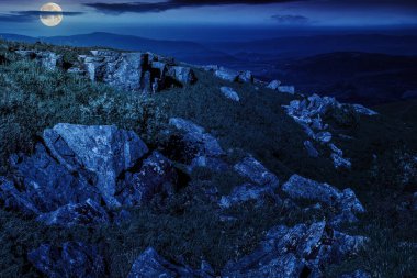 Geceleri dağ manzarasında yamaçta keskin taşlar. Dolunay ışığında gizemli doğa manzarası
