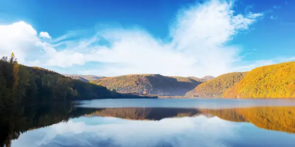ロマニアのレイクタウ湖で 秋の風景です 水面を映した鮮やかな秋の色の森林の丘 晴れた日のトランシルバニアの美しい自然の風景 ストックフォト