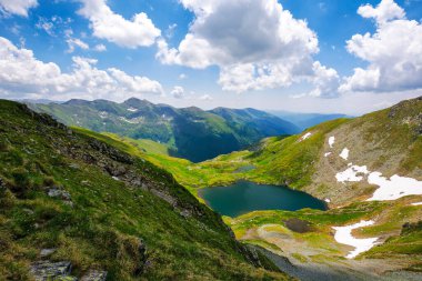 İbneler yazın Karpat Dağları manzarası. Güneşli bir günde tepeler arasında buzul gölü manzarası. Romanya ve Avrupa 'nın popüler seyahat beldesi 