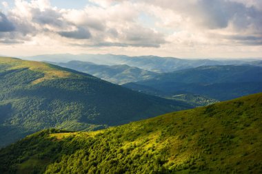 Yazın dağlık Ukrayna manzarası. Karpatlar 'ın dağlık tepeleri bulutlu gökyüzü ile ışık saçtı. güzel alp manzarası