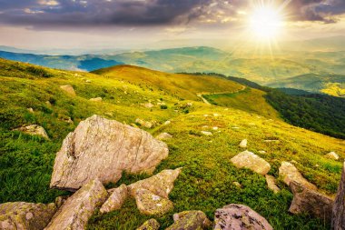 Gün batımında yüksek dağ sırasının çimenli çayırlarında beyaz, keskin kayalarla kaplı bir manzara. Akşam ışığında güzel Karpatya kırsal manzarası