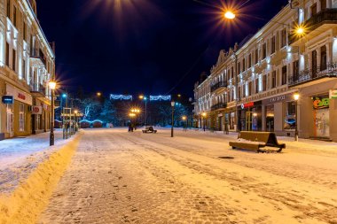 Uzhorod, Ukrayna - 06 Ocak 2019: Geceleri kış şehirleri. Yılbaşı aydınlanması. Sokaklar karla kaplı. Olay yeri Petofi Meydanı yakınında.