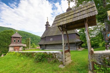 likitsary, transcarpathia, ukraine - jul 02, 2020: st. vasyl wooden church in carpathian mountains. amazing architecture landmark. sunny summer day clipart