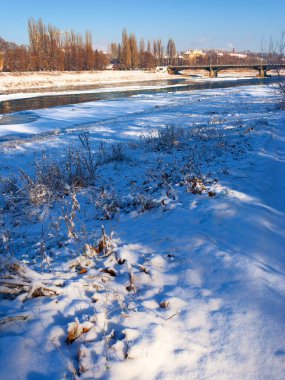 Uzhhorod, Ukrayna - 03 Ocak 2009: Donmuş nehir uz üzerindeki ulaşım köprüsü. Güneşli bir hava. Şehir merkezindeki eski şehir manzarası. Kasabada beyaz mevsim