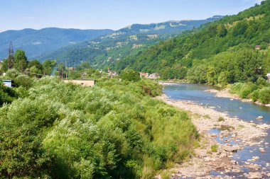 Tysa Nehri vadiden geçiyor. Tepedeki orman. Yazın güneşli bir hava. Ukrayna 'daki rakhiv bölgesinin dağlık kırsal arazisi. Karpat Dağları