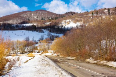 Karpat Dağları 'nda yol. Tepedeki orman. Kışın güneşli bir gün. Uzaktan macera