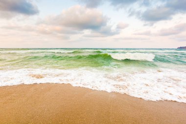 Dalgalar kumlu sahili yıkıyor. Açık hava macerası. Hava bulutlu. Akşamüstü Karadeniz manzarası. meteoroloji arka planı