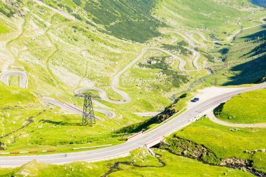 Transfagarasan yolu yokuş yukarı gidiyor. Açık hava macerası. Romanya 'nın dağlık arazisinde bir seyahat rotası. Yazın güneşli bir gün. Vadinin manzarası. Meşhur yol