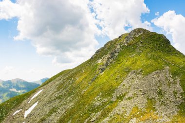 Yazın İbne Dağları manzarası. Romanya 'nın güzel doğa manzarası. Dik yamaçlar, çimenli yamaçlar ve güneşli bir günde mavi gökyüzünde bulutlar olan kayalık tepeler. manzaralı seyahat arkaplanı