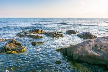 Karadeniz 'de güzel bir gün doğumu. Güzel manzara. Sabah ışığında mavi gökyüzünde kayalık sahil ve bulutlar. Yaz tatilleri ve hava değişimi konsepti. Sahilde rahatla.