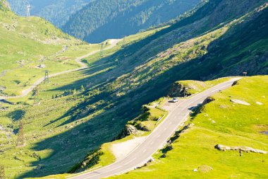 Transfagarasan yolu yokuş yukarı gidiyor. Güzel bir manzara. Romanya 'nın dağlık arazisinde bir seyahat rotası. Yazın güneşli bir gün. Vadinin manzarası. tehlikeli yol