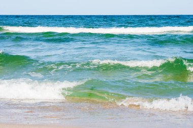 Yazın deniz manzarası. Altın kumu olan kumsal. Şeffaf sakin dalgalar ve mavi gökyüzü ile harika bir tatil geçmişi var. yeşil su