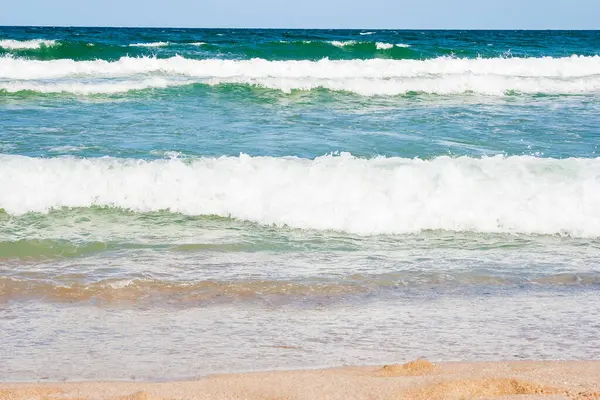 Yazın deniz manzarası. Altın kumu olan halk plajı. Şeffaf sakin dalgalar ve mavi gökyüzü ile harika bir tatil geçmişi var. İspanya 'nın popüler kıyıları