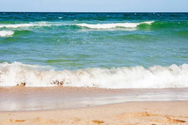 Yazın deniz manzarası. Altın kumu olan kumsal. Şeffaf sakin dalgalar ve mavi gökyüzü ile harika bir tatil geçmişi var. Kumlu deniz kıyısında macera