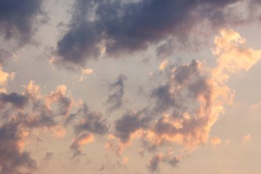 Gökyüzündeki kümülüs bulutları rüzgarla savruldu. Yumuşak bulutlu bir manzara. Bulutlu hava meteorolojisi arka planında turuncu ışık var. Akşam havası