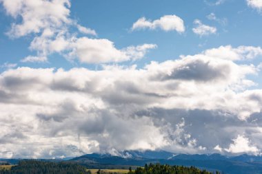 Eylül 'de dağların üzerindeki mavi gökyüzünde ağır bulutlar. Dramatik manzara. Karpatlar üzerinde sonbahar erken bulutlu hava. ukraine iklimi