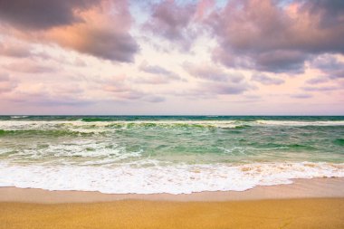 Karadeniz 'de bulutlu bir akşam gökyüzü. Köpüklü ve köpüklü gelgit. Doğada hava değişimi. Güzel turuncu bulutlar. Avrupa 'da sahilde dramatik bir yaz tatili