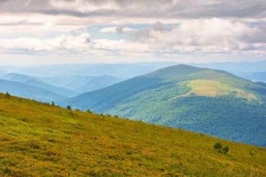 Soğuk havada dağ sıraları olan yaz manzarası. Uzanian Ulusal Park Vadisi manzarası. Bulutlu gökyüzünün altında benekli ışıkta alp manzarası