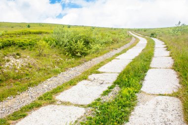 Eski beton dağ yolu. Bulutlu bir günde pürüzsüz bir dağın içinden geçen yol. Ukrayna 'ya git. Karpatya manzarası