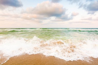Dalgalar kumlu sahili yıkıyor. Yaz tatili. Hava bulutlu. Akşamüstü Karadeniz manzarası. güzel manzara