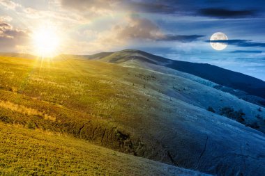 Yaz gündönümünde yeşil çayırlar olan dağ manzarası. Gündüz ve gece zaman kavramını değiştirir. Alacakaranlıkta güneşli ve aylı kavramsal seyahat hedefinin resimsel duvar kağıdı. Uzaktaki büyük zirve.