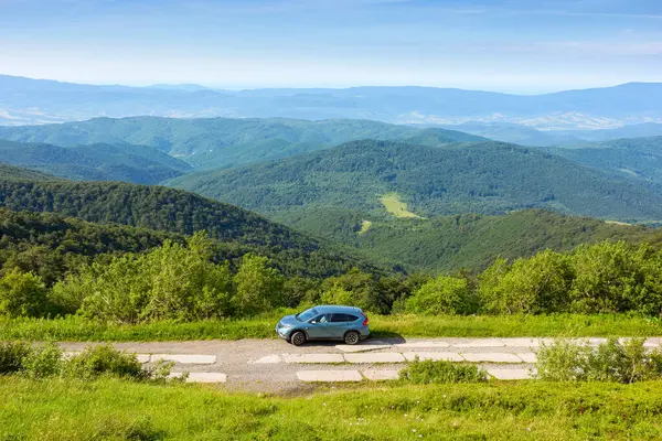 Perechyn, Ukrayna - 02 Haziran 2020: 4wd kırsal bir dağ yolunda. Yamaçta seyahat için Cyan SUv. Güneşli bir yaz sabahında uzak vadi perechyn bölgesinin manzarası