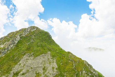 Yazın İbne Dağları manzarası. Romanya 'nın güzel doğa manzarası. Dik yamaçlar, çimenli yamaçlar ve güneşli bir günde mavi gökyüzünde bulutlar olan kayalık tepeler. manzaralı seyahat arkaplanı