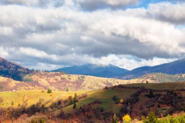 Sonbaharda güzel bir dağ manzarası. Bulutlu gökyüzü. Ukrayna Alpleri ve ormanlarının resmedilmeye değer doğası. Güneşli bir gün. Dağlık yamaçlı sakin duvar kağıtları.