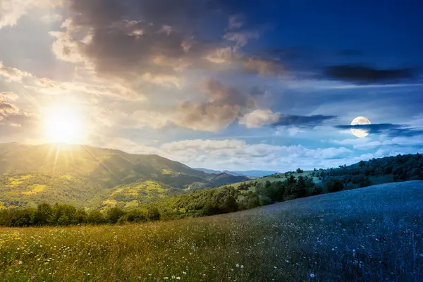 Yaz gündönümünde güneş ve ay ile geniş çayırlı dağ manzarası. Çayırdaki çimenler kırsal alandaki tepelerden uzak Alp Vadisi 'ne yuvarlanıyor. Gündüz ve gece zaman kavramını değiştirir