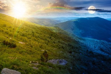 Yaz gündönümünde yeşil tepeyle seyahat etmek için harika bir dağ manzarası. Uzak vadiye manzaralı doğa manzarası. Güneş ve ay ile birlikte. İskoçya 'da gece ve gündüz konsepti değişir.