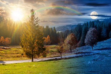 Sonbahar ekinoksunda kırsal dağ manzarası. Kırsal yol vadiden geçiyor. Gündüz ve gece zaman kavramını değiştirir. Gezi sezonunda manzaralı manzara ve güneşli ve aylı açık hava macerası