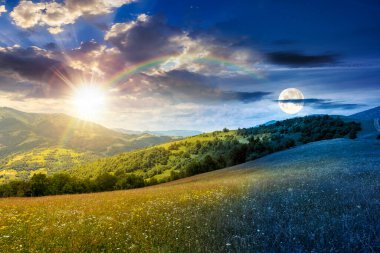 Yaz gündönümünde güneş ve ay ile geniş çayırlı dağ manzarası. Çayırdaki çimenler kırsal alandaki tepelerden uzak Alp Vadisi 'ne yuvarlanıyor. Gündüz ve gece zaman kavramını değiştirir
