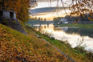 Uzhhorod, Ukrayna - 31 Ekim 2009: Sonbaharın şafağında nehir uzh. Sabah ışığında güzel bir şehir manzarası. Sonbahar renklerinde manzaralı ıhlamur yolu. Yere düşen yapraklar.