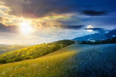 Yaz gündönümünde güneş ve ay ile geniş çayırlı dağ manzarası. Çayırdaki çimenler kırsal alandaki tepelerden uzak Alp Vadisi 'ne yuvarlanıyor. Gündüz ve gece zaman kavramını değiştirir