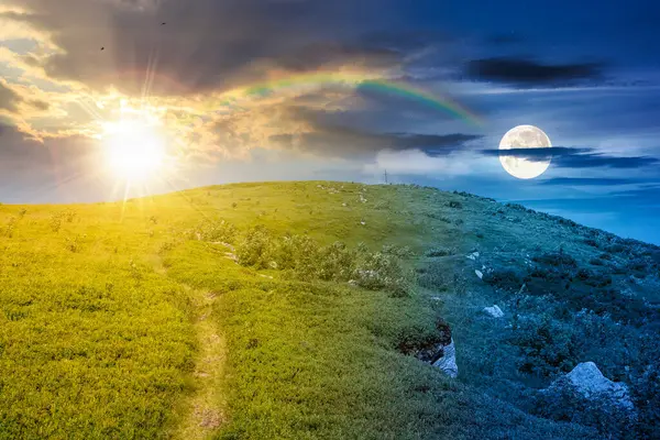 Yaz ortasında dağ manzarası. Gündüz ve gece zaman kavramını değiştirir. Yeşil tepe ve mavi gökyüzü. Alp manzarasında seyahat etmek için doğal bir arka plan. Alacakaranlıkta güneşli ve aylı huzurlu manzara