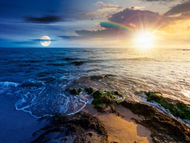 Kumsalda kum var. Gündüz ve gece zaman kavramını değiştirir. Deniz kenarında yaz gündönümü. Güneşin altında sakin dalgalar ve alacakaranlıkta ay olan güzel deniz manzarası. Gökyüzünün altında kabarık bulutlarla deniz manzarası