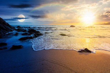 Yaz gündönümünde alacakaranlıkta deniz manzarası. Güneşli ve aylı bir gökyüzünün altındaki deniz manzarası. Gündüz ve gece zaman kavramını değiştirir. Doğadaki saflık. Yaz ortası pagan tatilini denizde kutluyoruz.