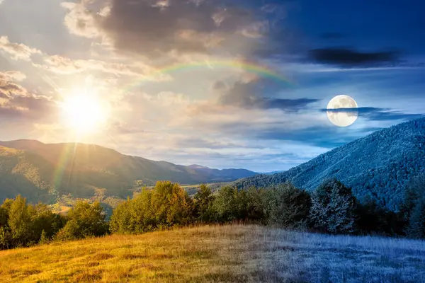 Sonbahar ekinoksu sırasında tepesinde orman olan dağ manzarası. Gündüz ve gece zaman kavramını değiştirir. Kırsal vadiye güzel bir manzara. Alacakaranlıkta güneş ve ayın olduğu dağlık arazi manzarası