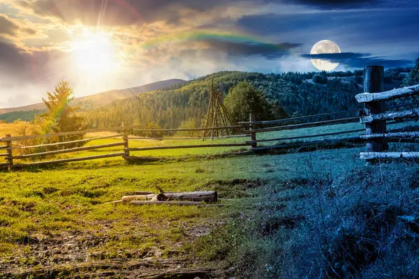 Sonbaharda dağlık kırsal alan. Gündüz ve gece zaman kavramını değiştirir. Yamaçtaki çimenli çayırdan geçen patikanın yanındaki ahşap çit. Dağlarda köknar ormanı, güneş ve ay manzarası.