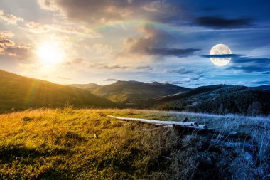 Sonbahar ekinoksunda kırsal dağ manzarası. Gündüz ve gece zaman kavramını değiştirir. Tepelerdeki kırsal alan. Çimenli çayırlar ve dağlık yamaçlarda güneşli ve aylı güzel manzaralar.