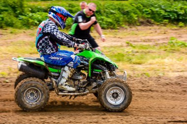 Uzhhorod, Ukrayna - 21 Mayıs 2017: ATV sürücüsü toprak yolda hızlanıyor. Çamurdaki yeşil dört tekerlekli aracın spor müsabakası