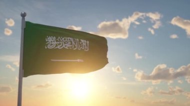Suudi Arabistan bayrağı rüzgarda, gökyüzünde ve arka planda dalgalanıyor.