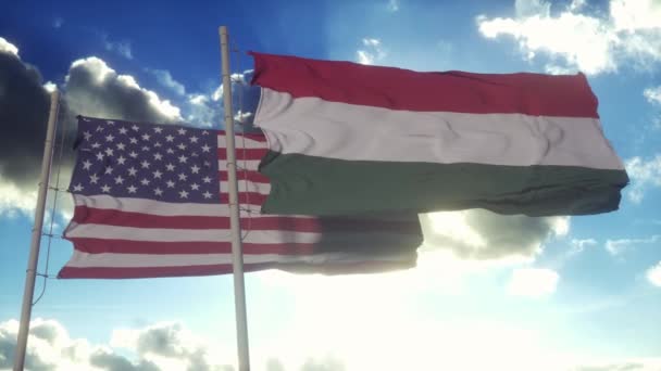 ハンガリーとアメリカ合衆国は旗竿に旗を掲げた ハンガリーとアメリカの風の中でフラグを振って ハンガリーとアメリカ合衆国の外交概念 — ストック動画