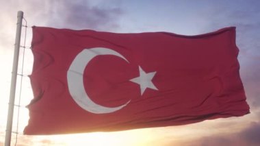 Türkiye bayrağı rüzgarda dalgalanıyor, gökyüzü dramatik.