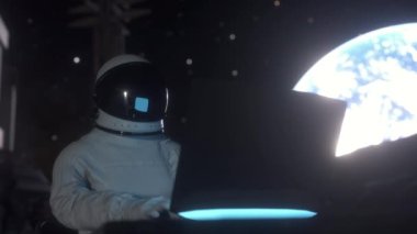Astronot bir uzay kolonisinde bilim dizüstü bilgisayarı üzerinde çalışıyor..