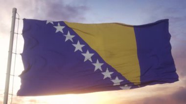 Bosna-Hersek bayrağı rüzgarda, gökyüzünde ve arka planda dalgalanıyor.