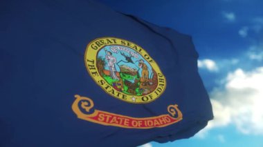 Idaho eyalet bayrağı rüzgarda sallanıyor. Mavi gökyüzü arka planı. 4K.