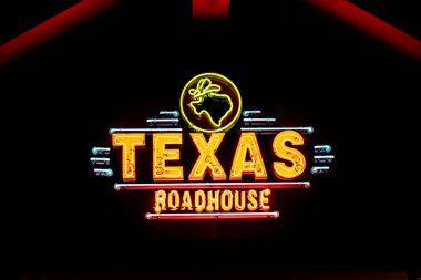 WOODBURY, MN, ABD - 4 ARALIK 2023 Teksas Roadhouse restoranının dışı ve geceleri ticari marka logosu.