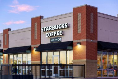 STILLWATER, MN, ABD - 7 ARALIK 2023: Starbucks kahve restoranının dışı alacakaranlıkta ve ticari marka logosu.