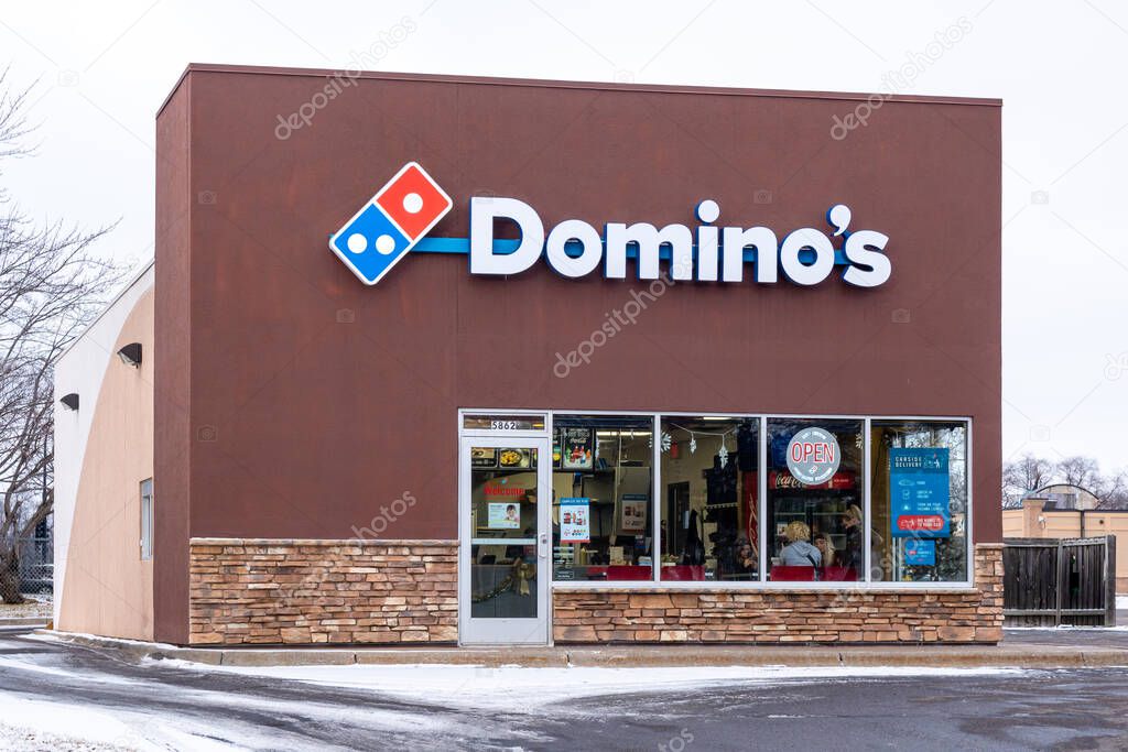 NORTH BRANCH, MN, USA - JANUARY 1, 2024:  Dominos Pizza exterior and trademark logo.
